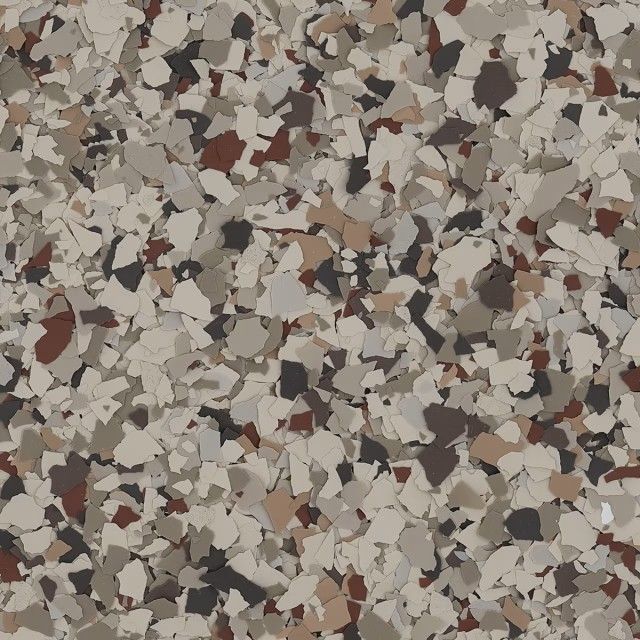 A close-up of multi-colored vinyl paint chips in shades of tan, brown, black, and cream for garage floor coating.
