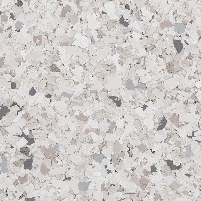 A textured surface with a speckled pattern of small white, light gray, beige, and dark charcoal flakes.