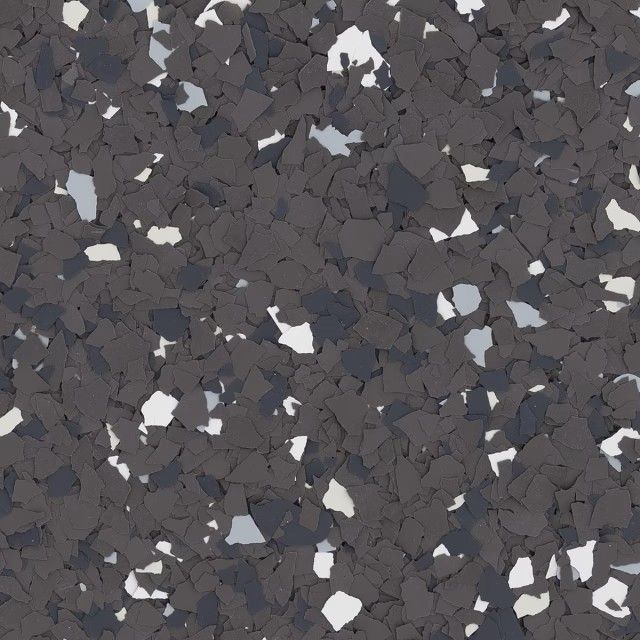 A textured floor surface covered in a speckled mix of dark gray, black, light gray, and white vinyl paint chips.
