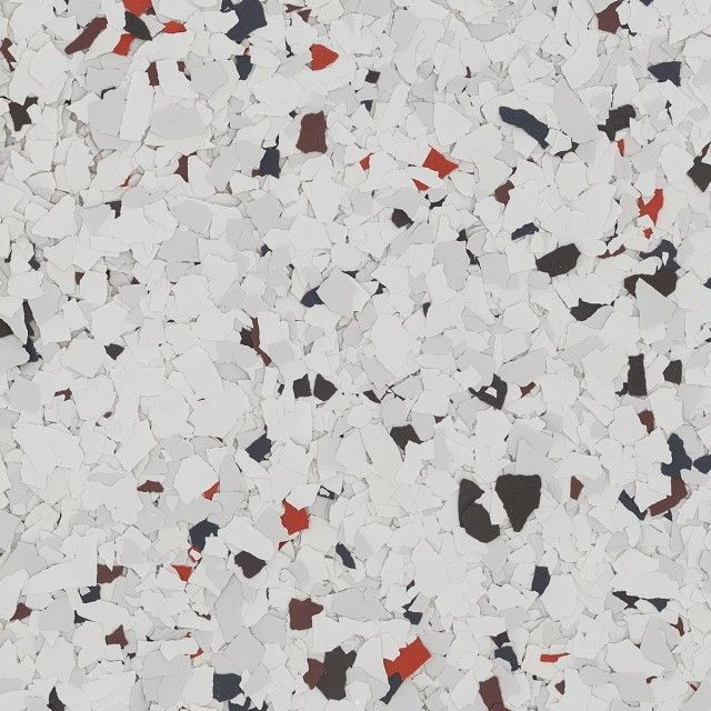 A textured floor coating with a speckled pattern of white, light gray, dark charcoal, and red vinyl flakes.