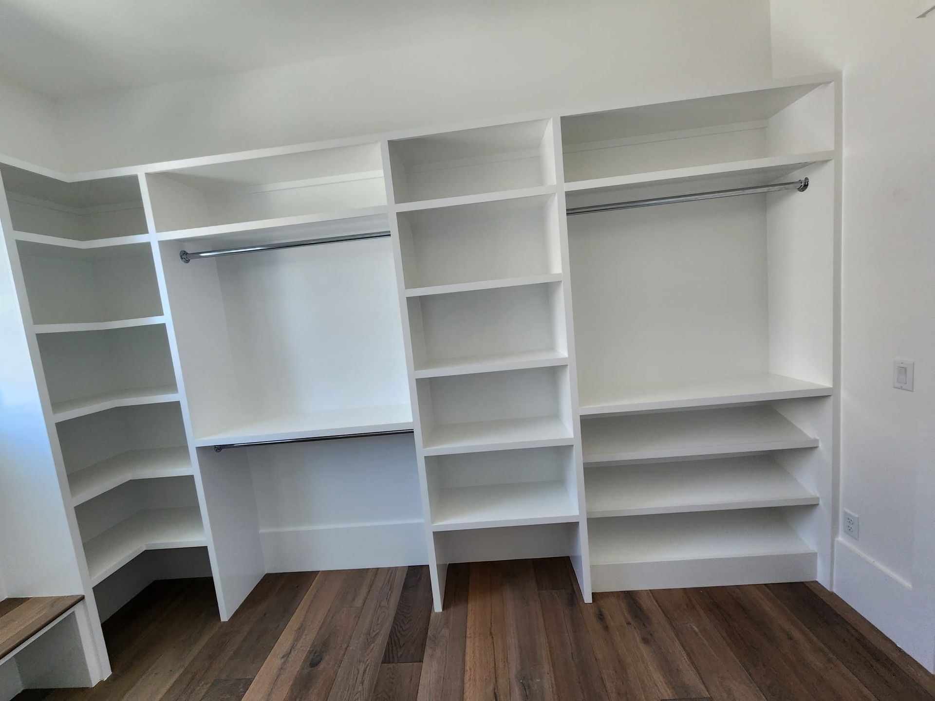 a closet with lots of shelves and a wooden floor