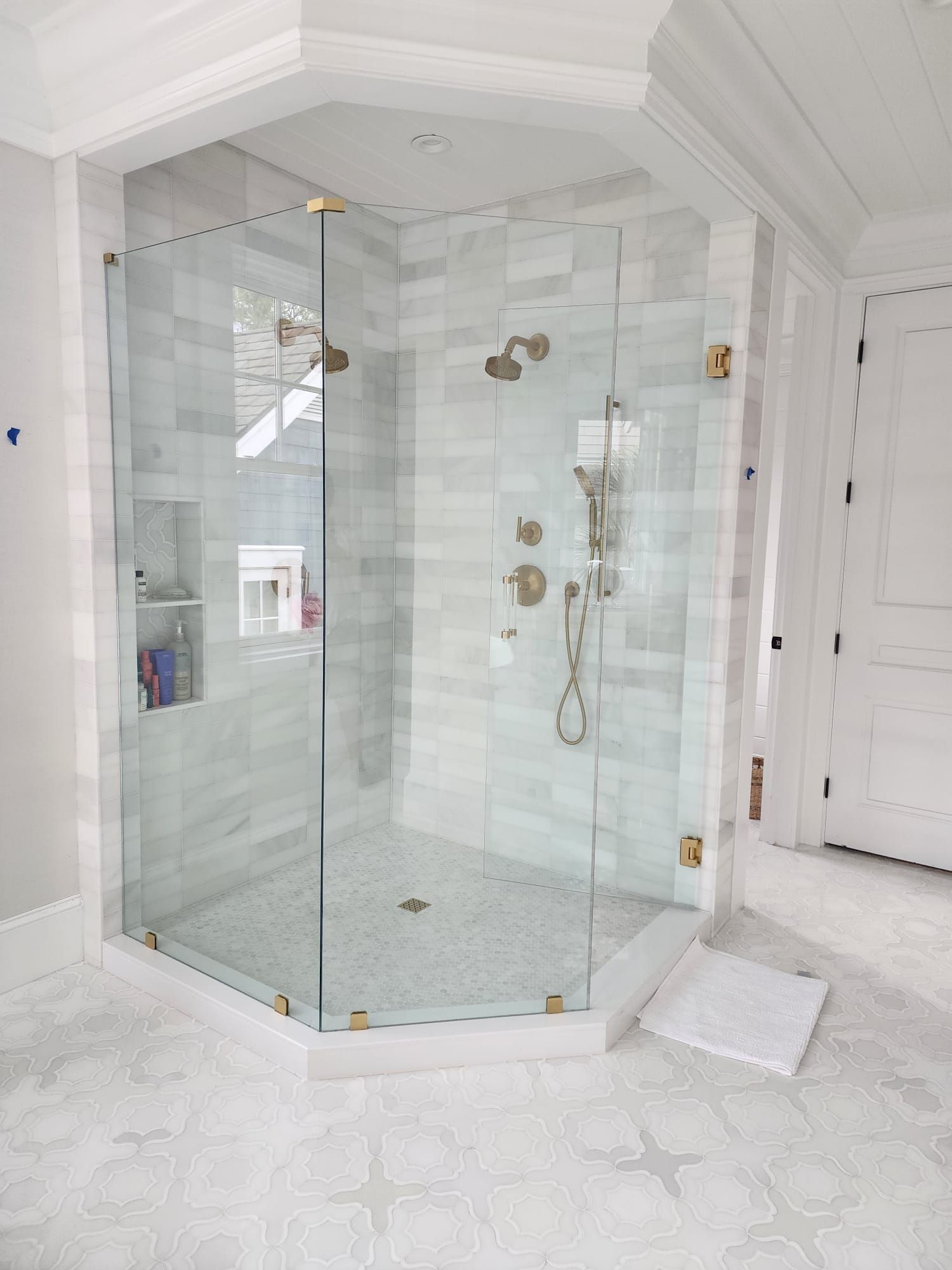 a bathroom with a walk-in shower with a glass door