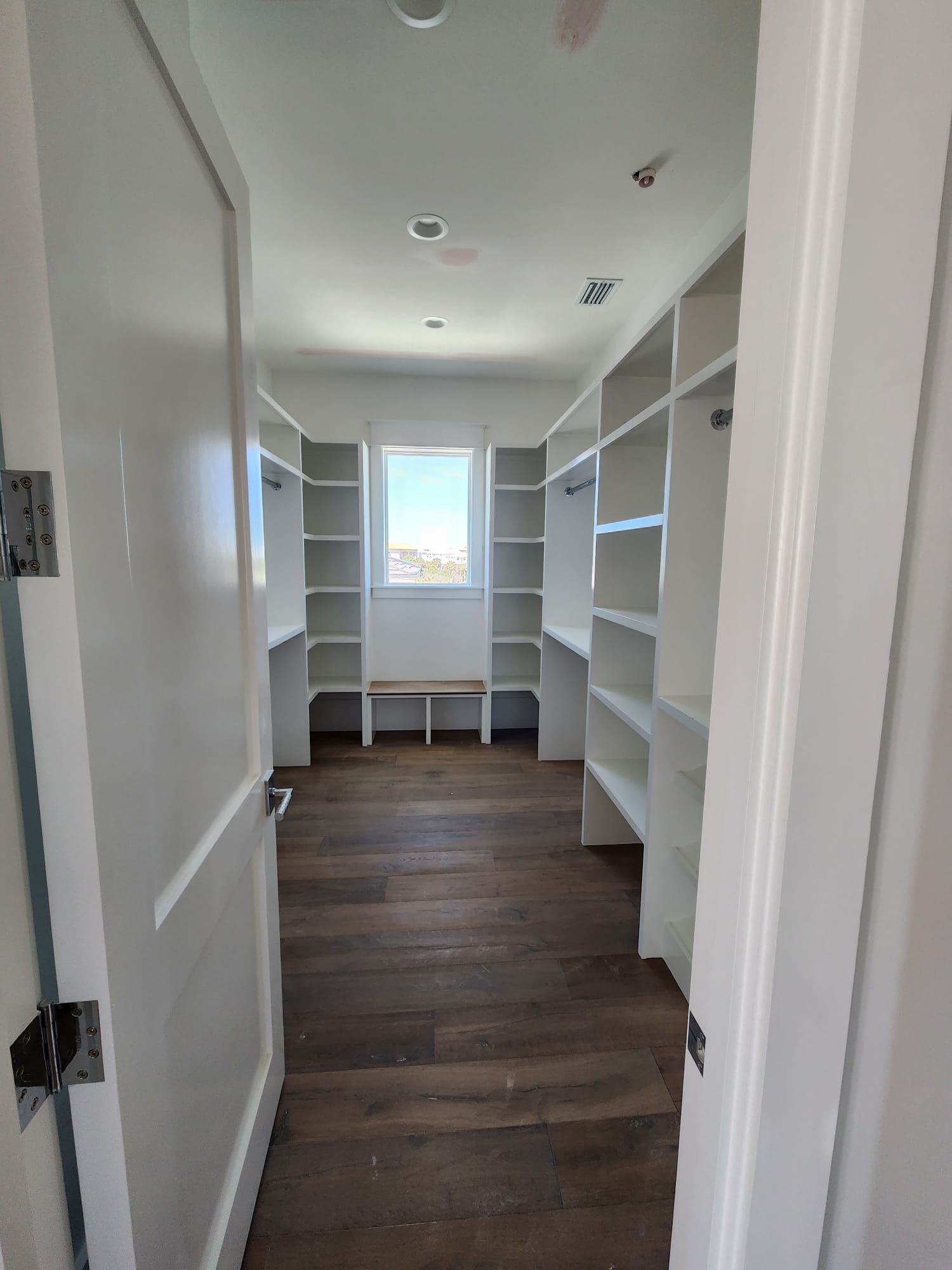 a walk-in closet with lots of shelves and a window