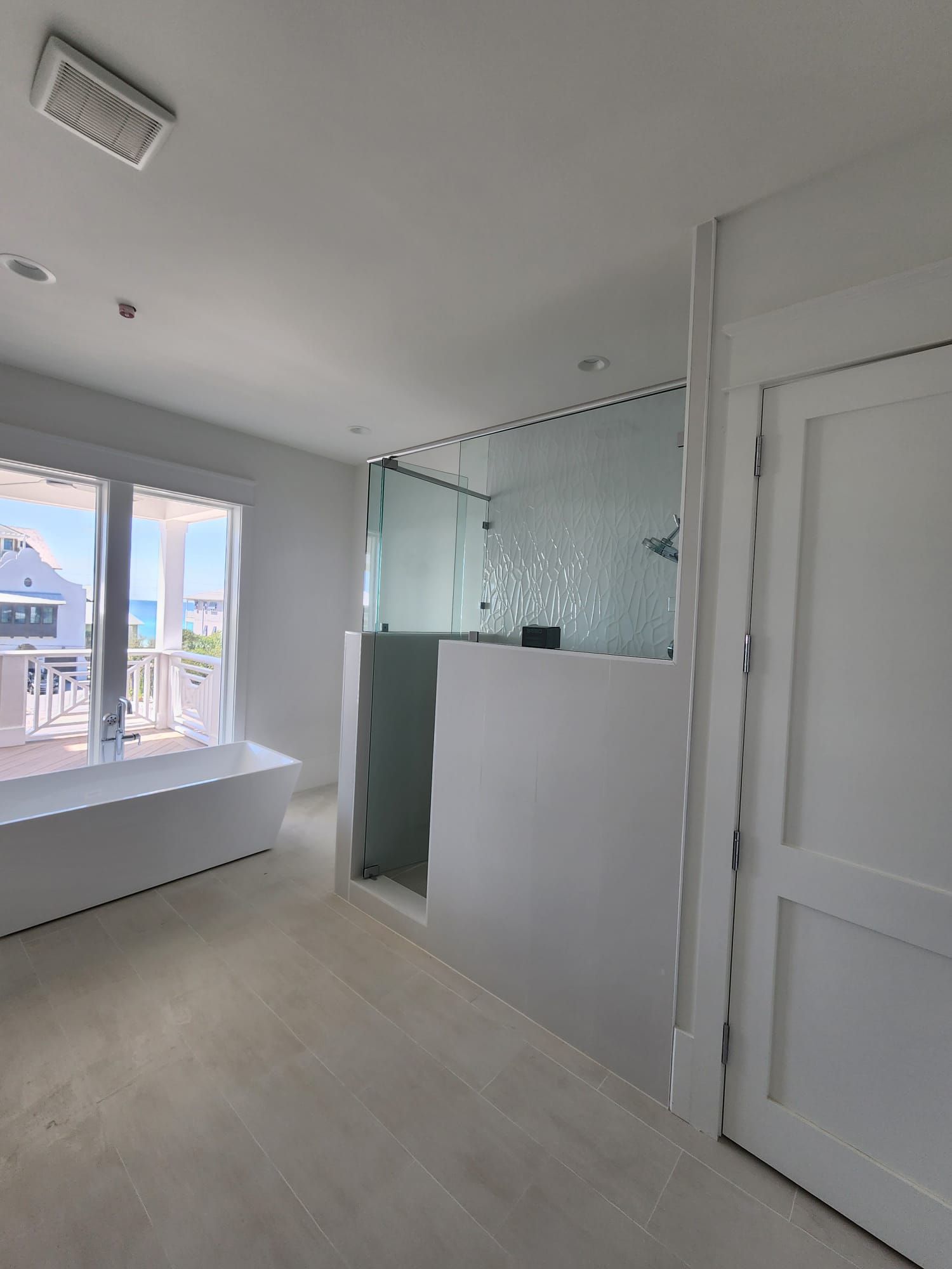 an empty room with a large window and a walk-in shower