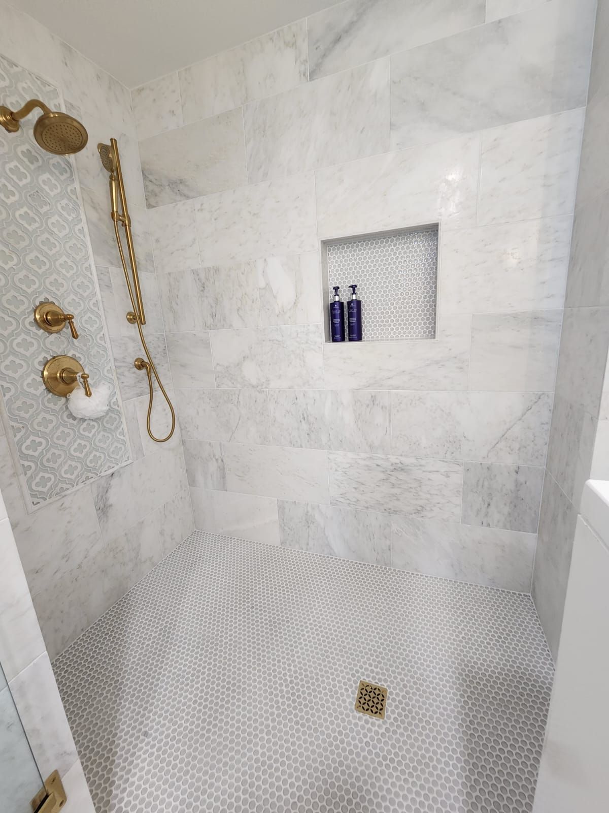 a bathroom with a walk-in shower and a marble tile floor