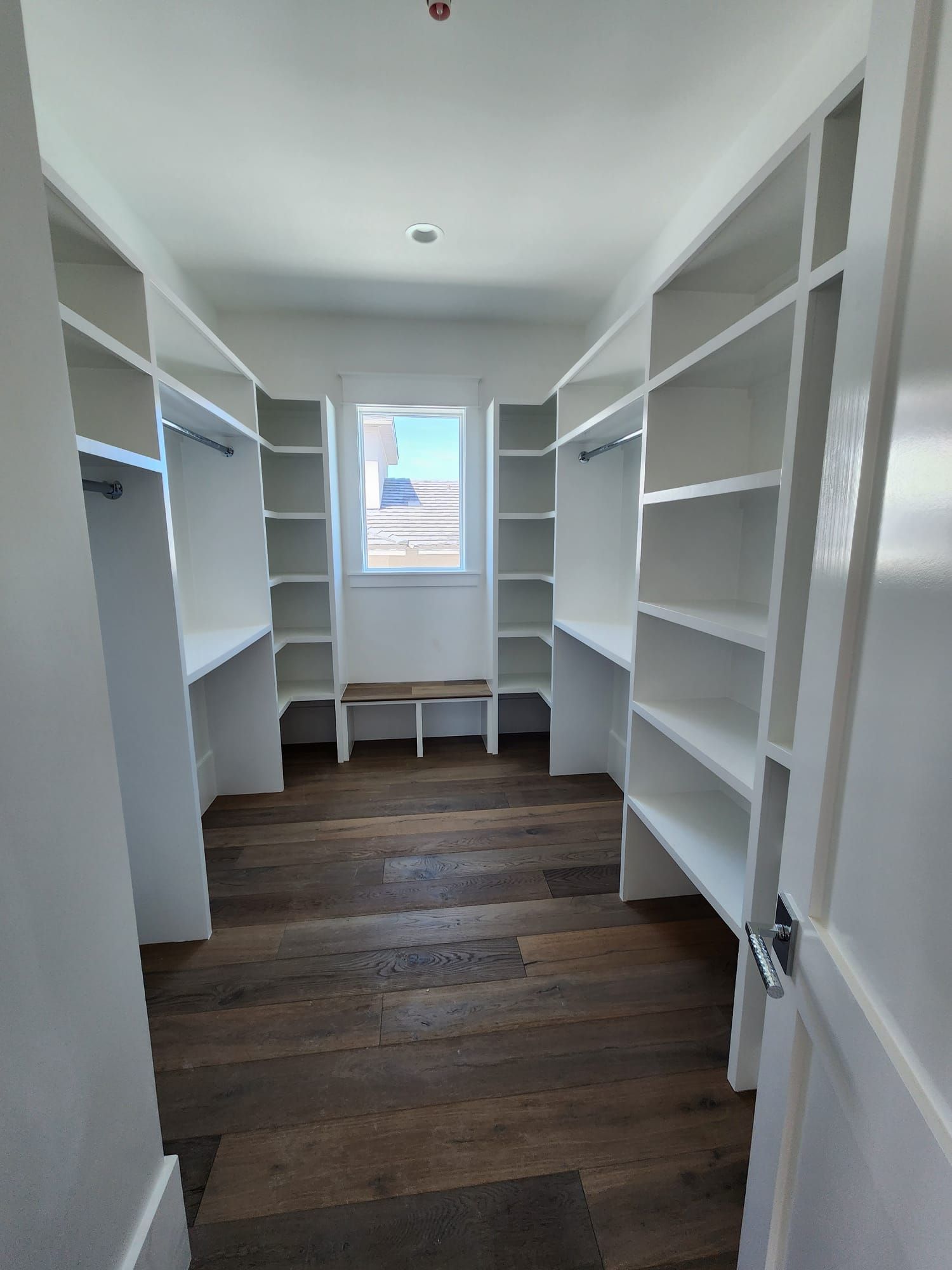 a walk-in closet with lots of shelves and a window