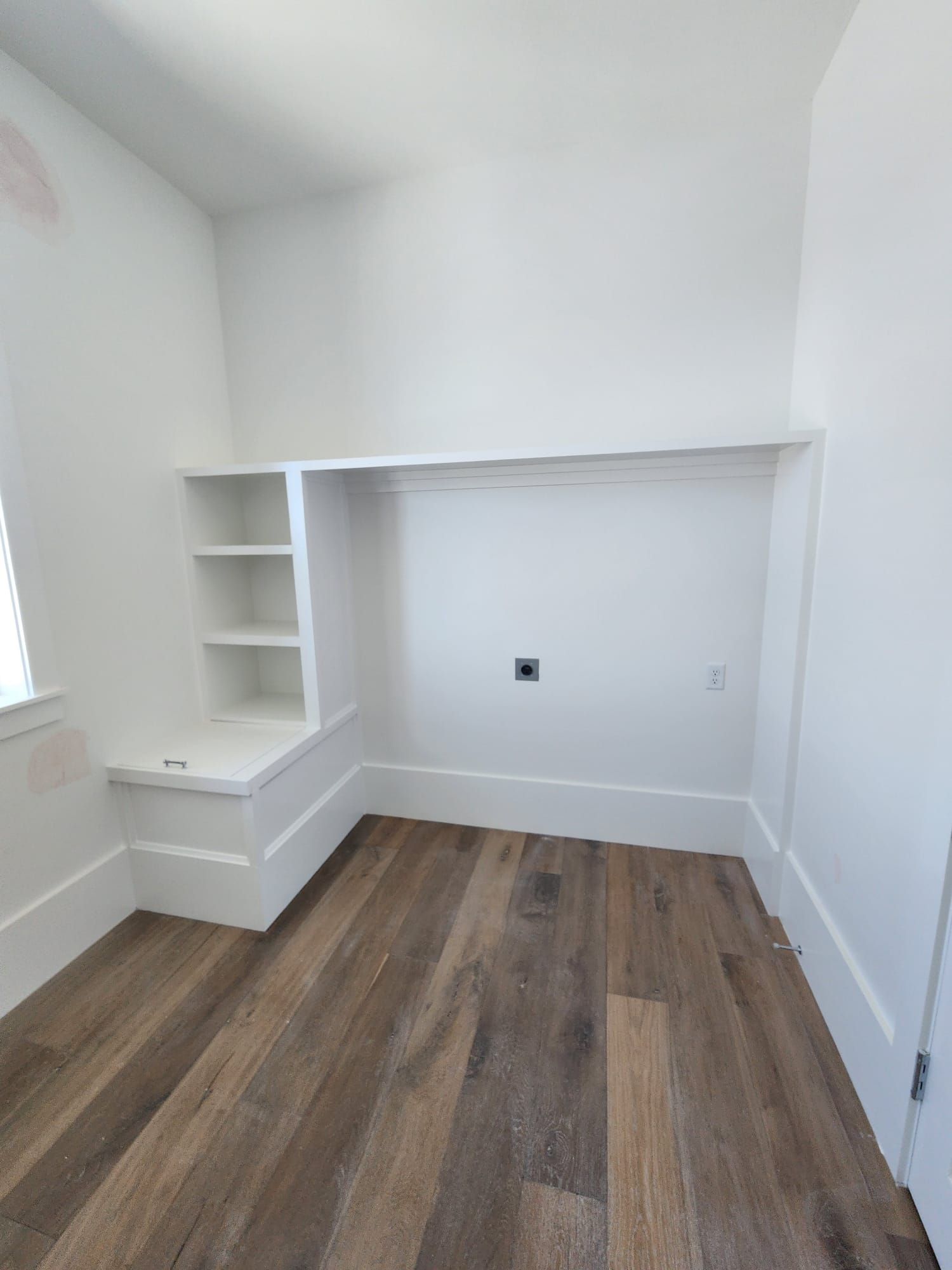 an empty room with hardwood floors and white walls