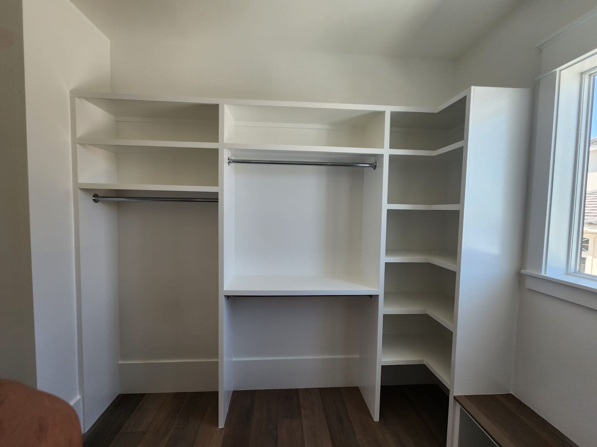a walk-in closet with lots of shelves and a window