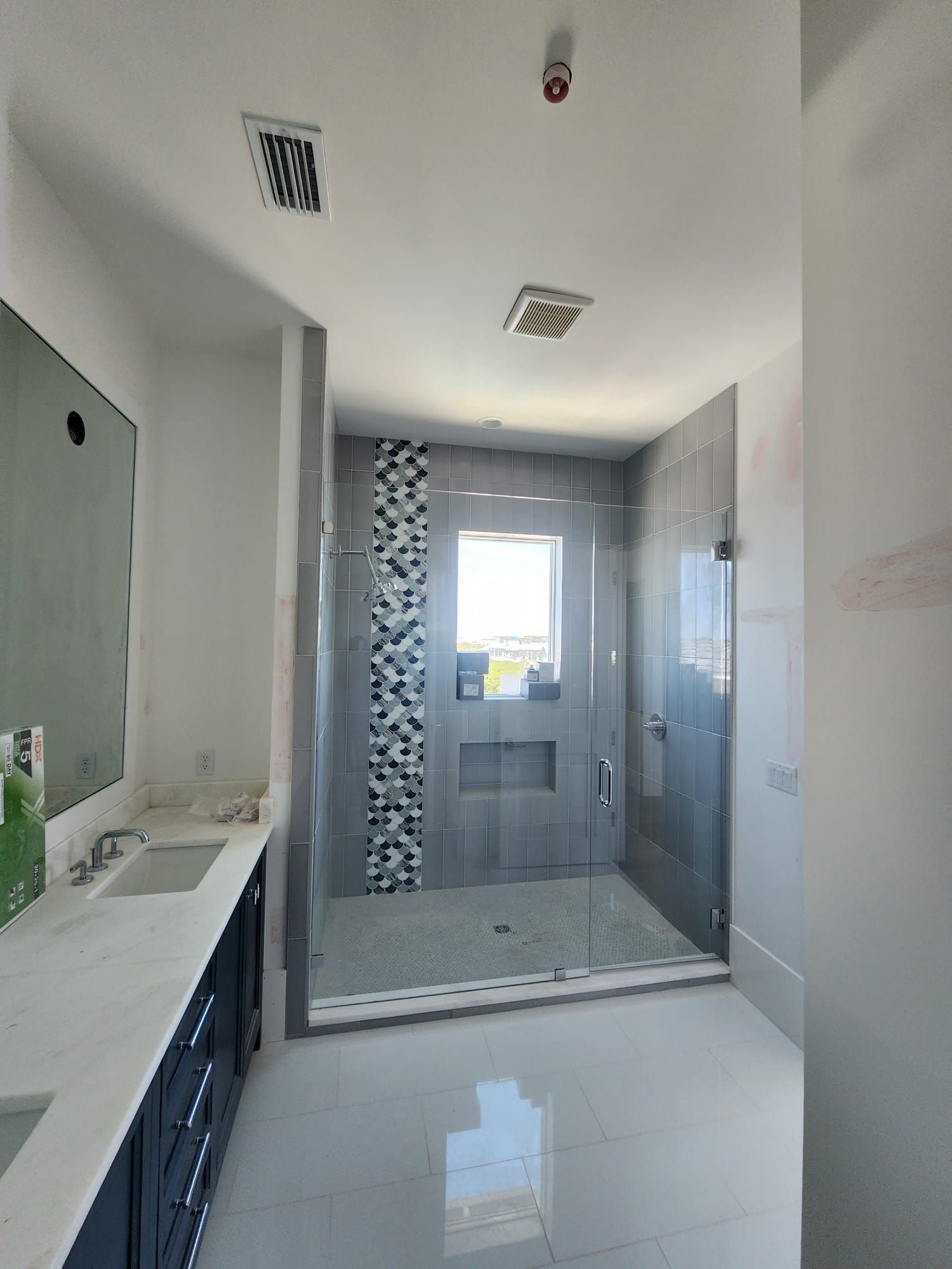 a bathroom with two sinks and a walk-in shower