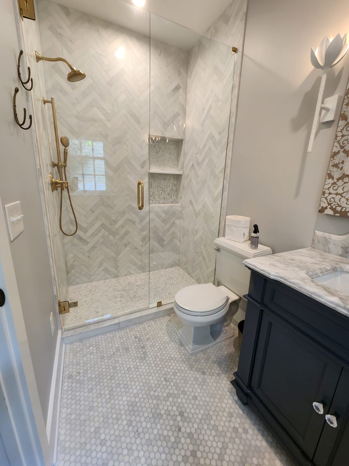 a bathroom with a toilet , sink , shower and glass door .