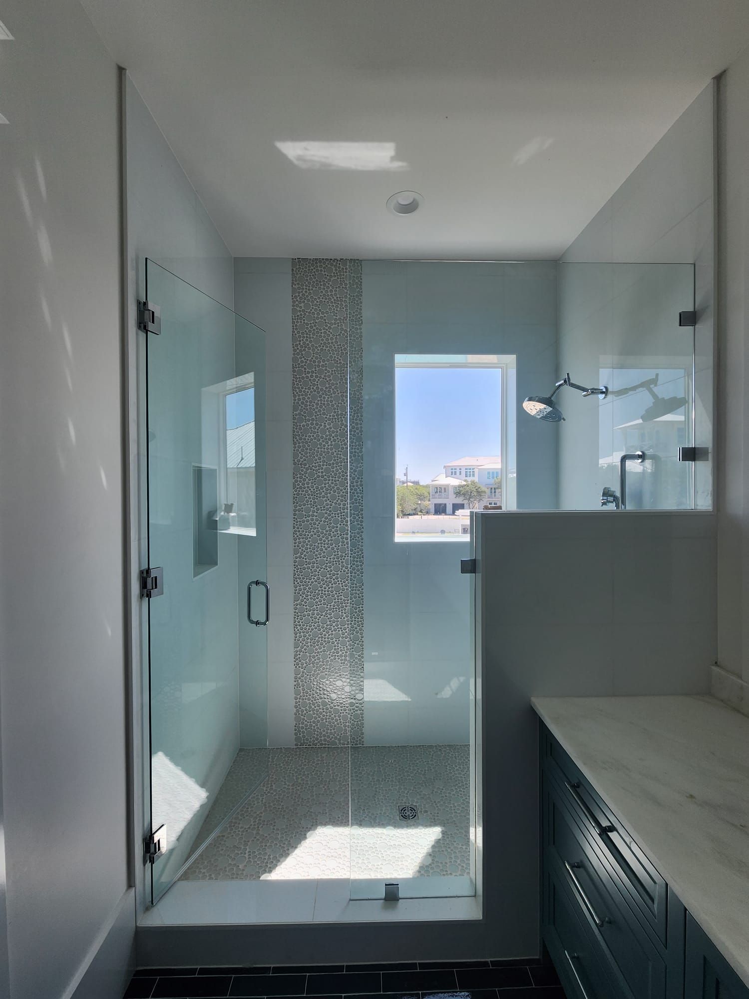 a bathroom with a walk-in shower and a window