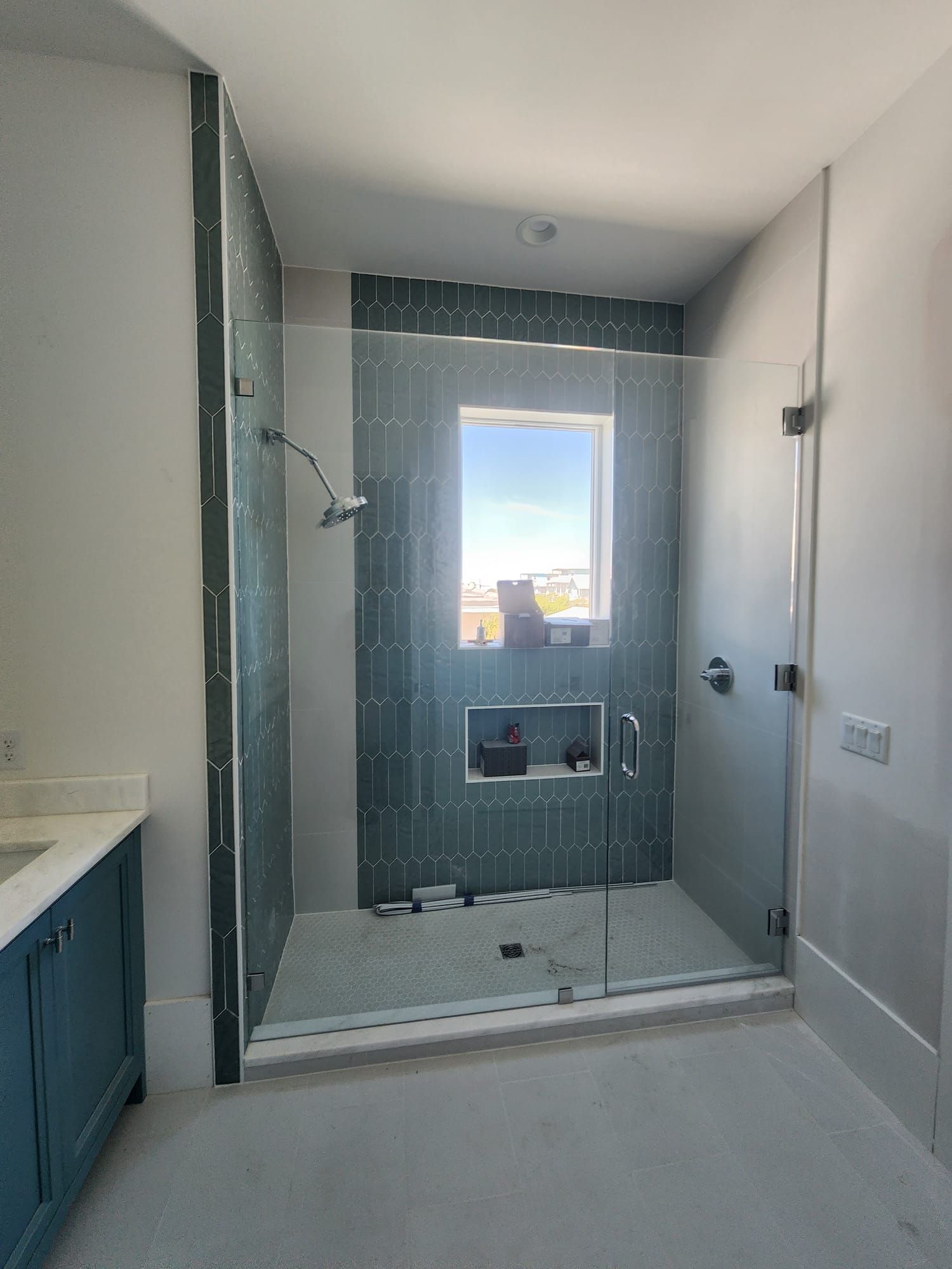 a bathroom with a walk-in shower and a window
