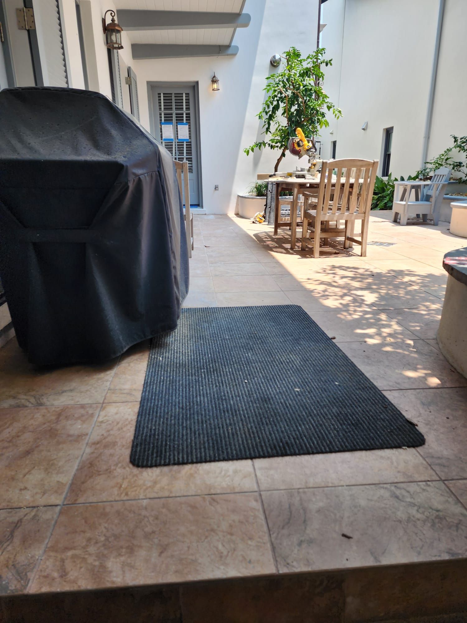 a patio with a table and chairs and a black rug