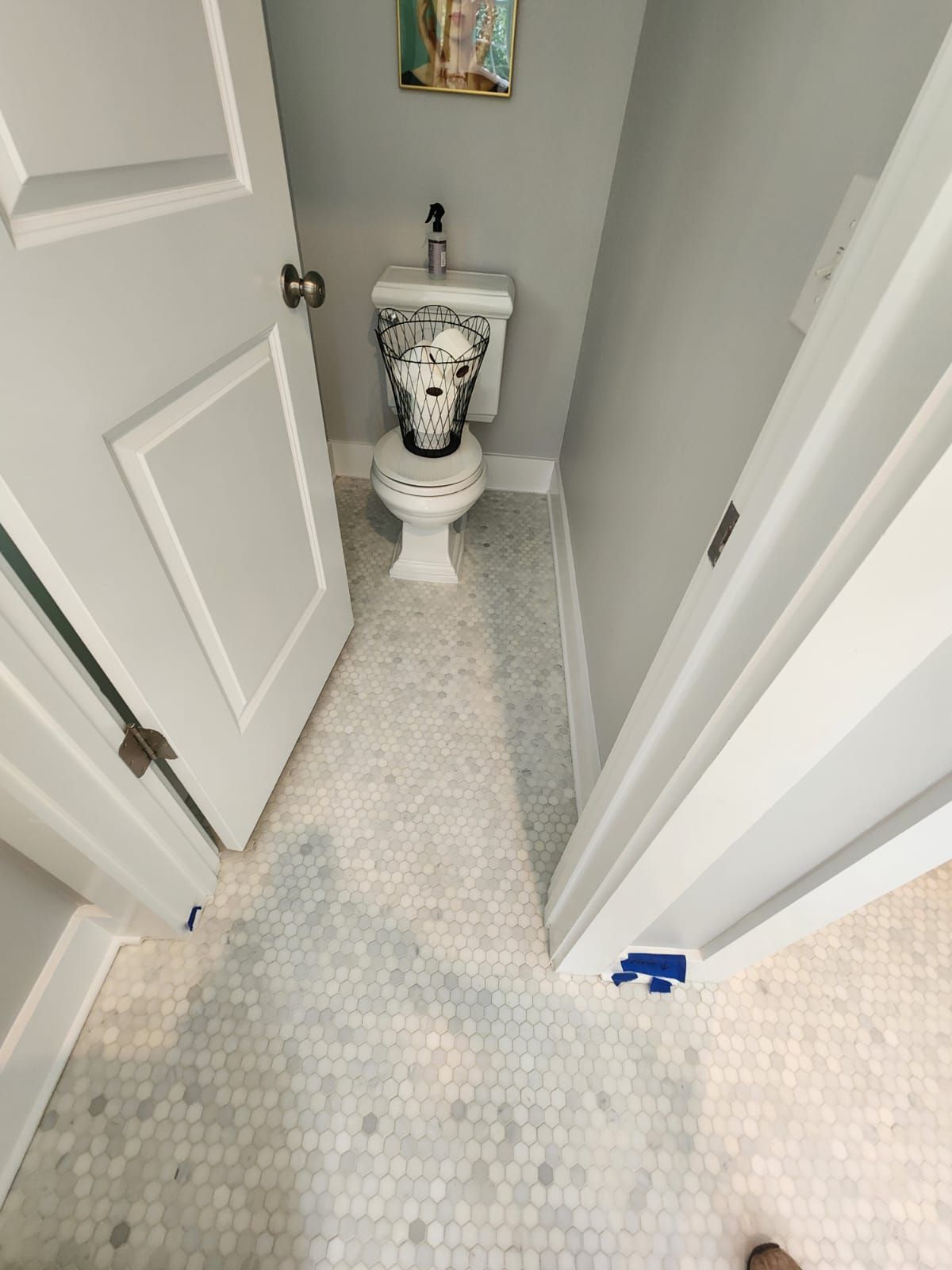 a bathroom with a toilet and a basket of toilet paper