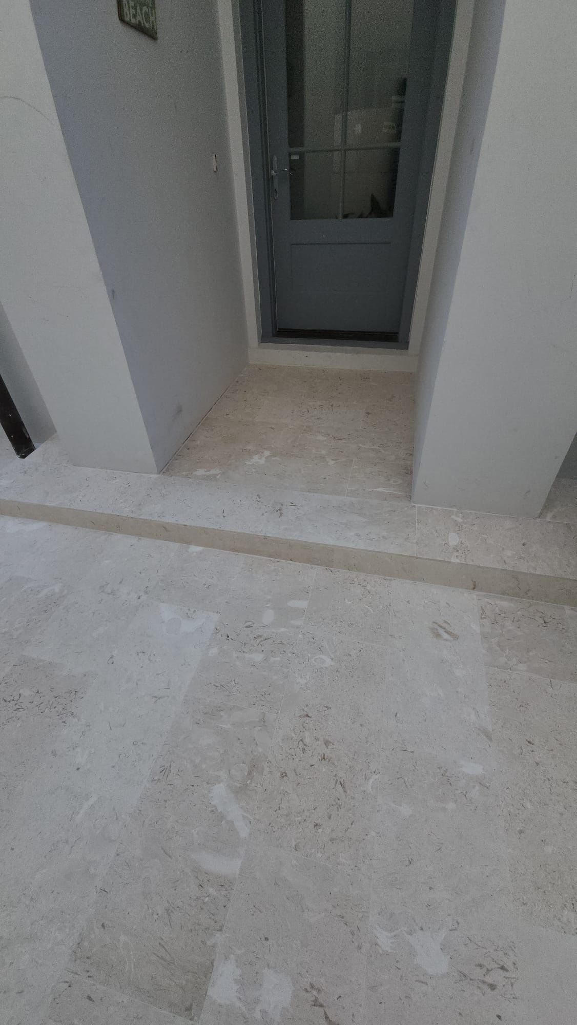 a white tiled floor in a room with a door