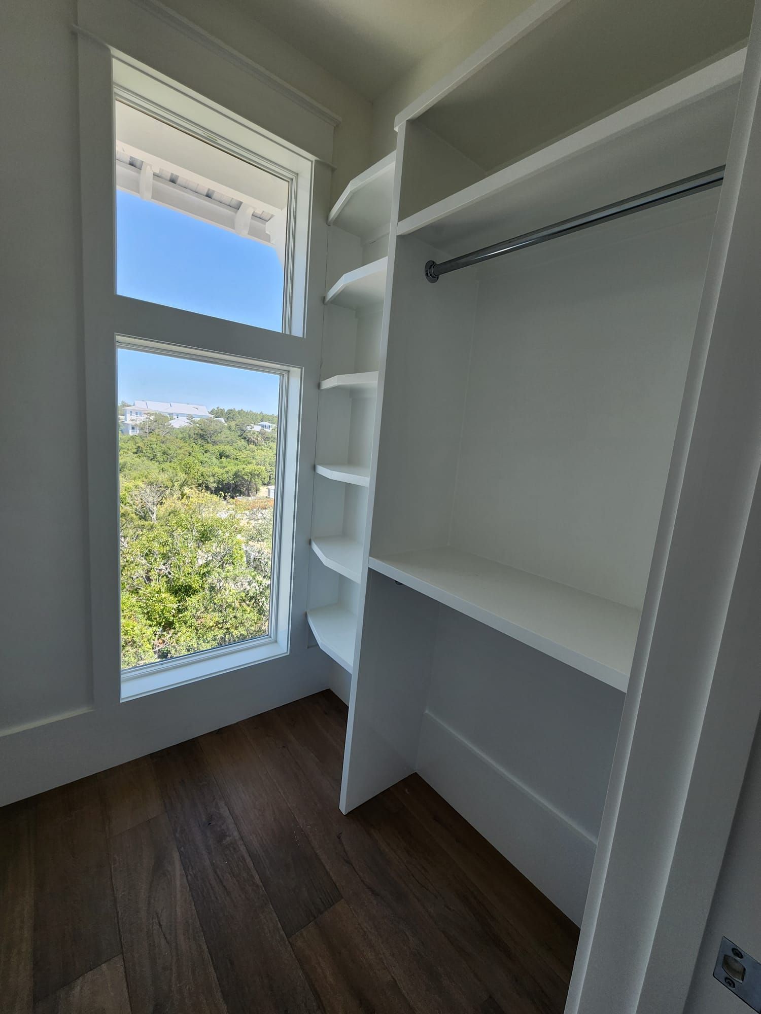 a walk-in closet with a large window and shelves