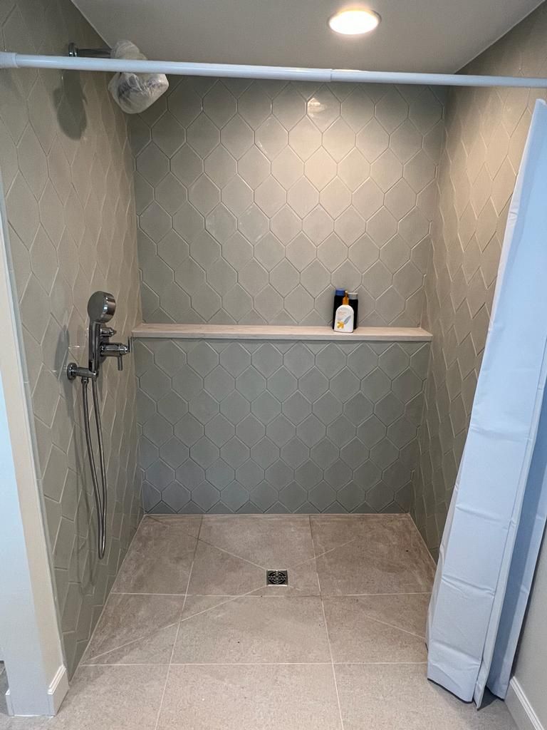 a bathroom with a walk-in shower and a shelf