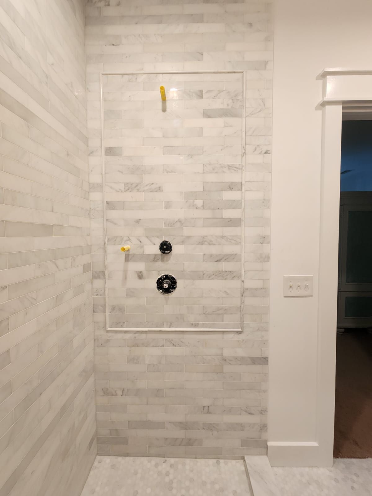 a bathroom with white tile walls and a walk-in shower