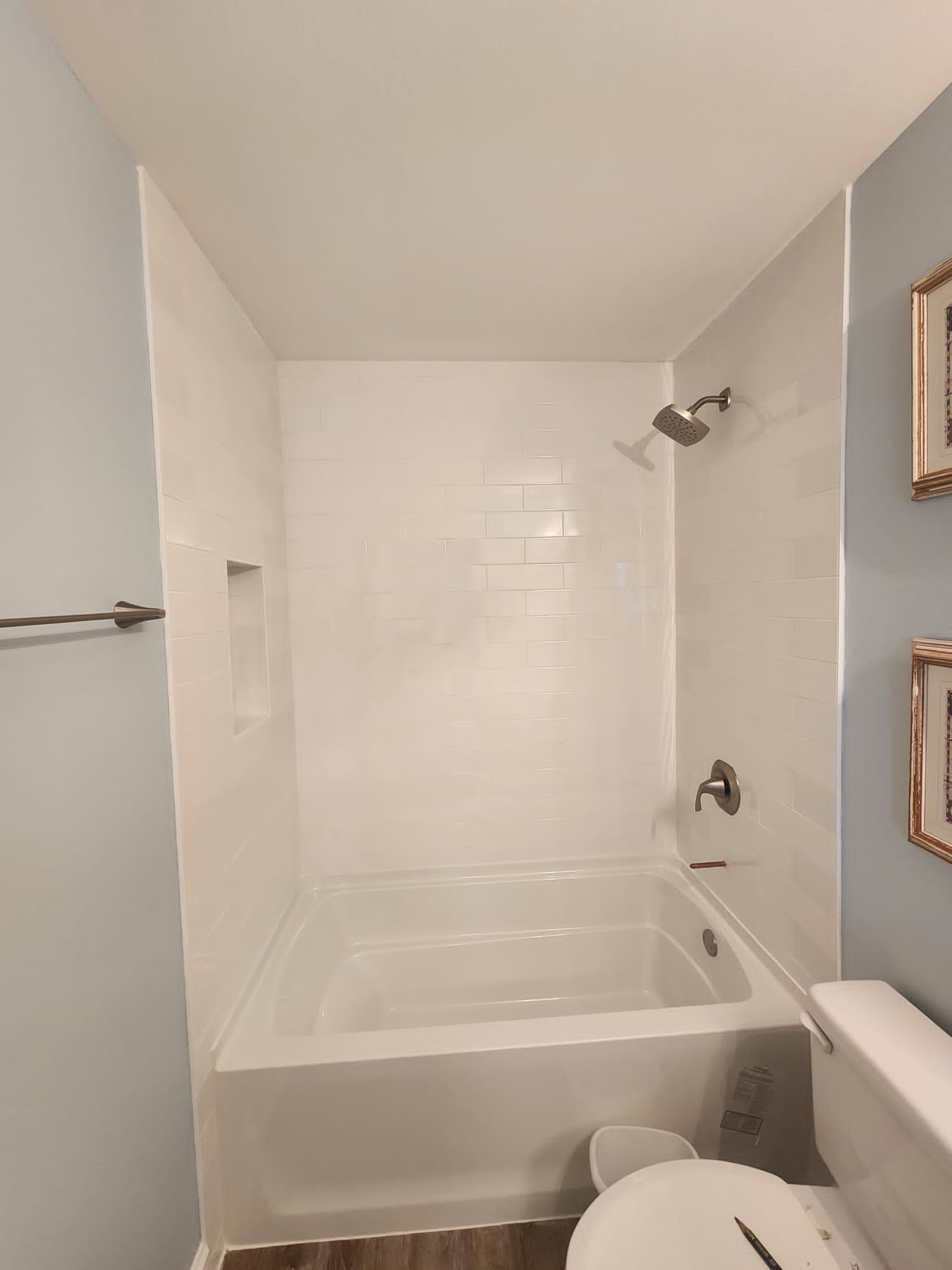 a bathroom with a tub, toilet and shower