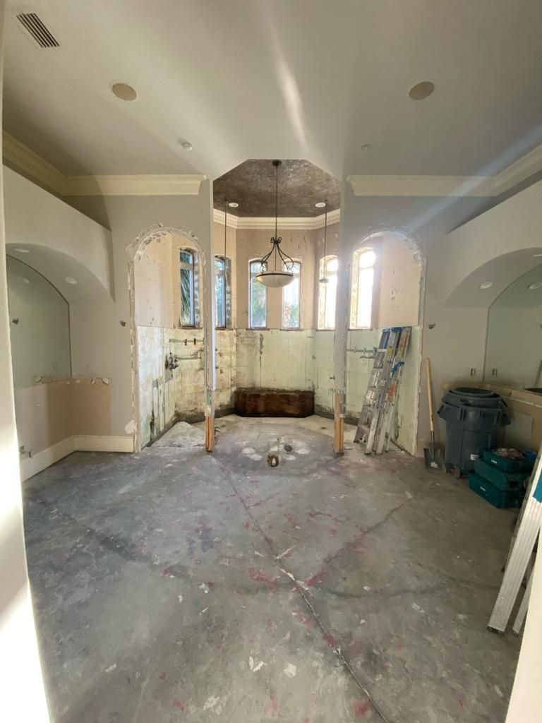 a large room with a ceiling fan and a ladder in it