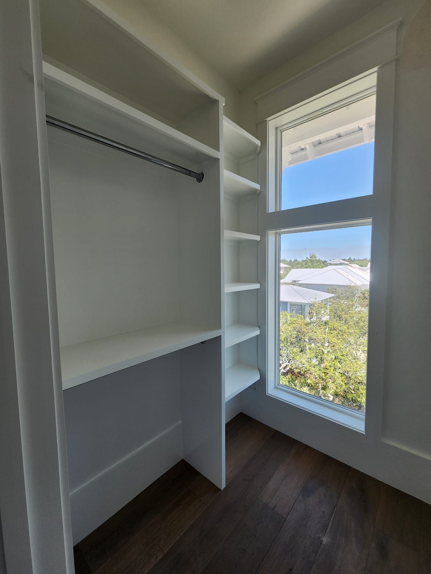 a walk-in closet with a large window and shelves