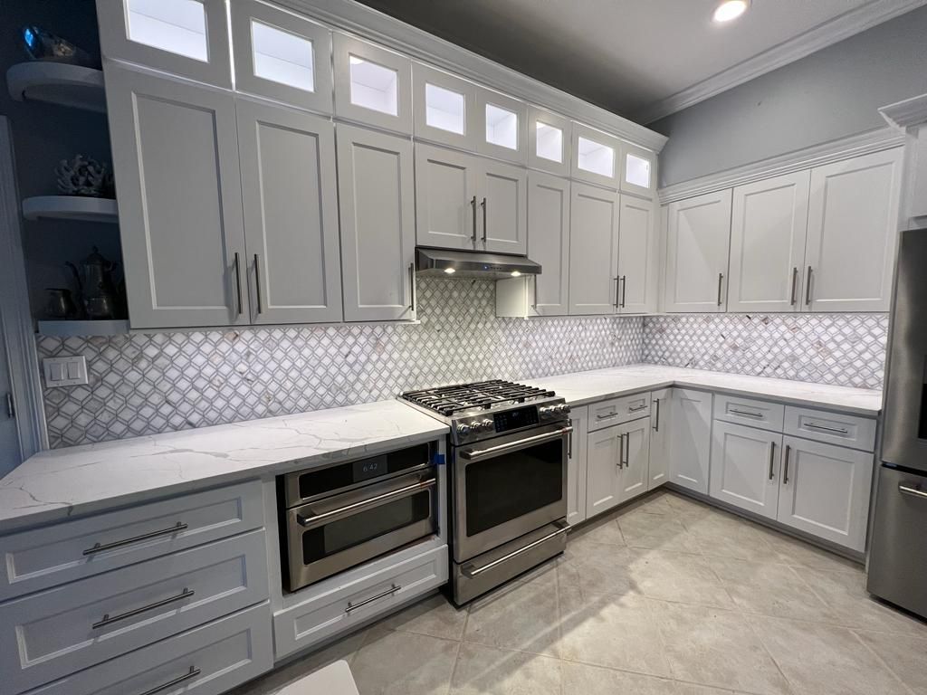a kitchen with white cabinets and stainless steel appliances