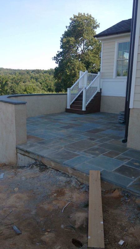 A house with a patio and stairs in front of it.