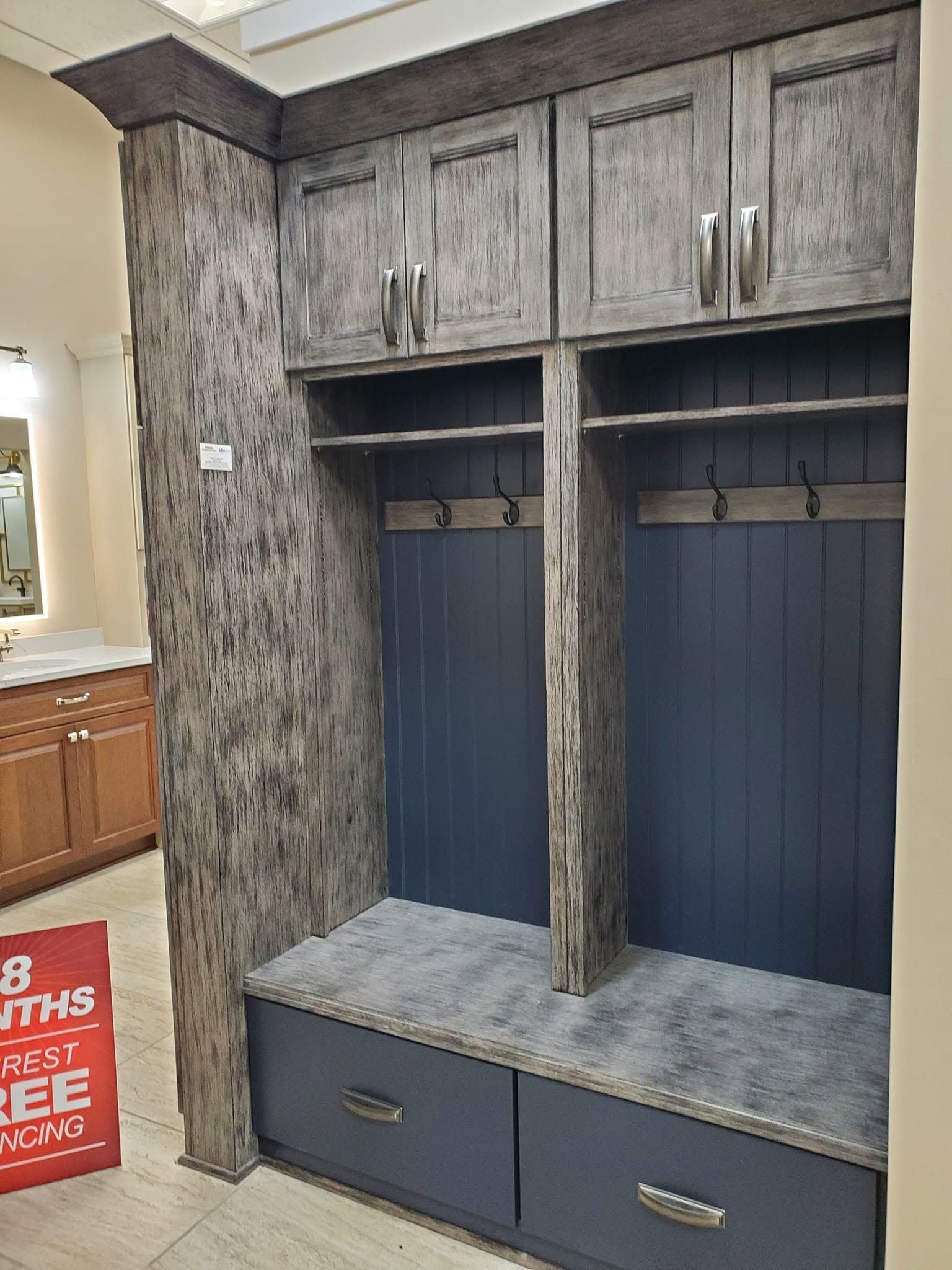 Built-in hallway mudroom bench with navy cubbies, gray stone top, and overhead cabinets