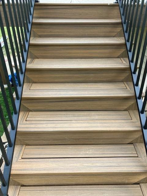 Wooden outdoor staircase with black metal railings on both sides