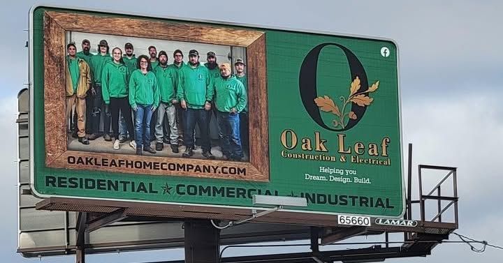 Billboard for Oak Leaf Home Co. with green-clad workers