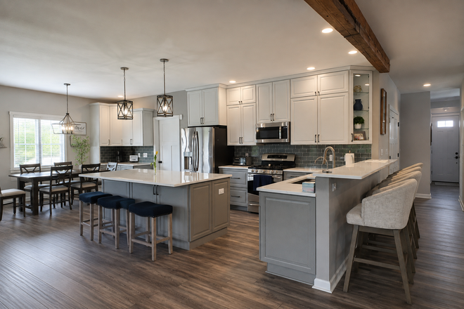 Spacious modern kitchen and dining area with white cabinets, island seating, and wood floors