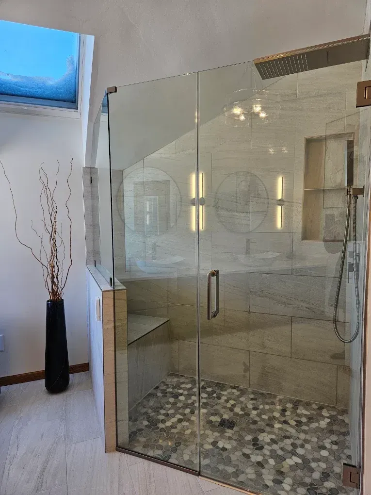 Modern bathroom with freestanding tub, black tile floor, large windows, and wood vanity cabinets