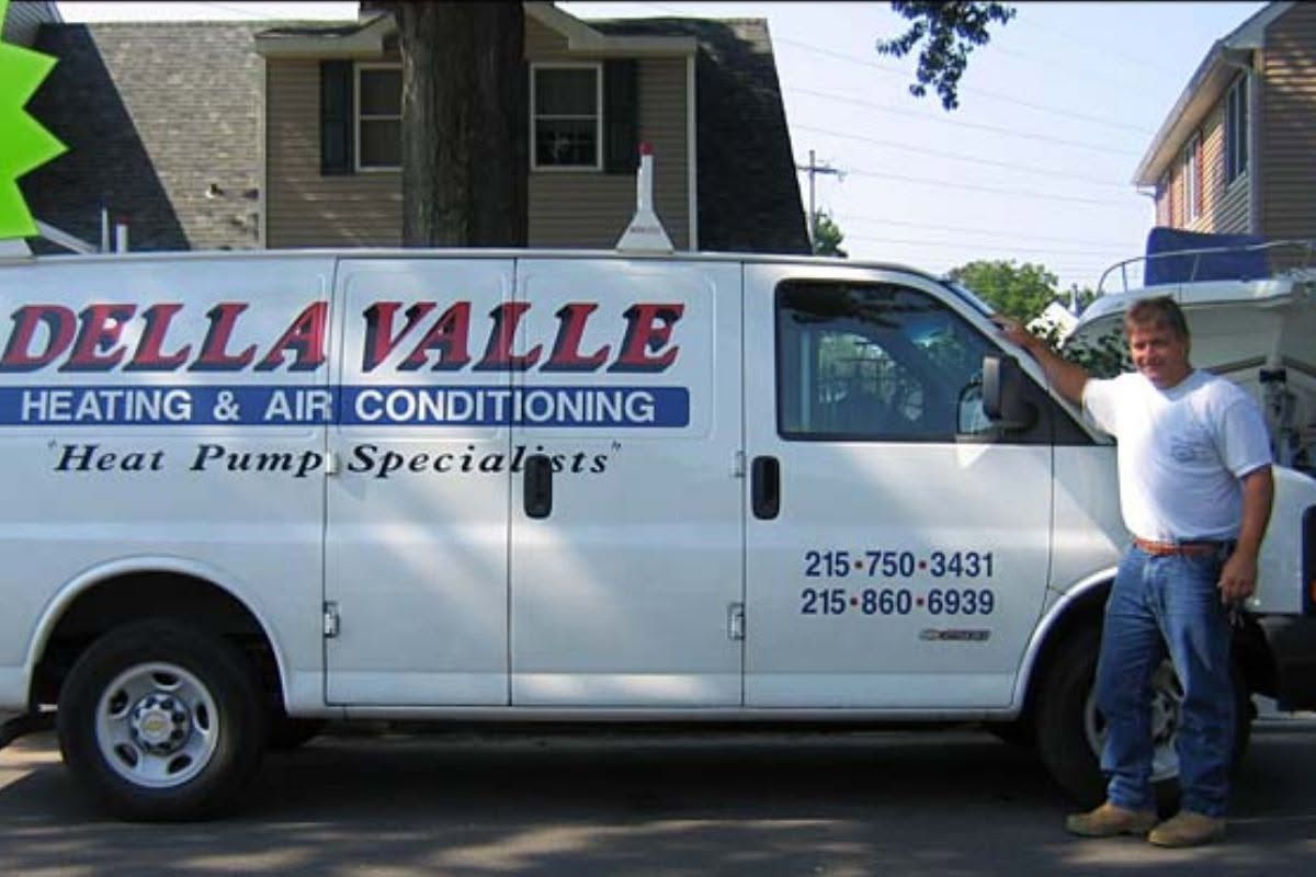 Dellaville heating and air conditioning van parked beside a man in a white shirt