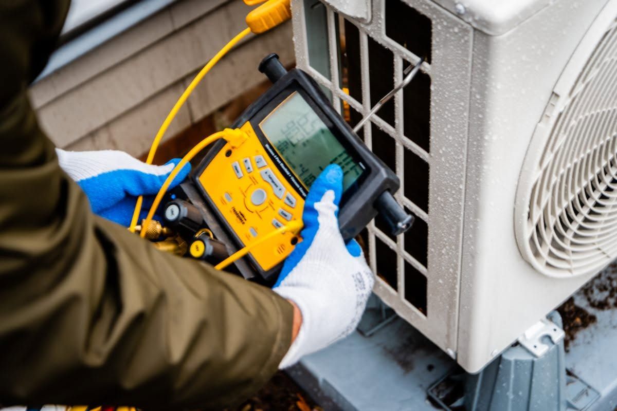 Technician using a digital multimeter to test an outdoor air conditioner unit