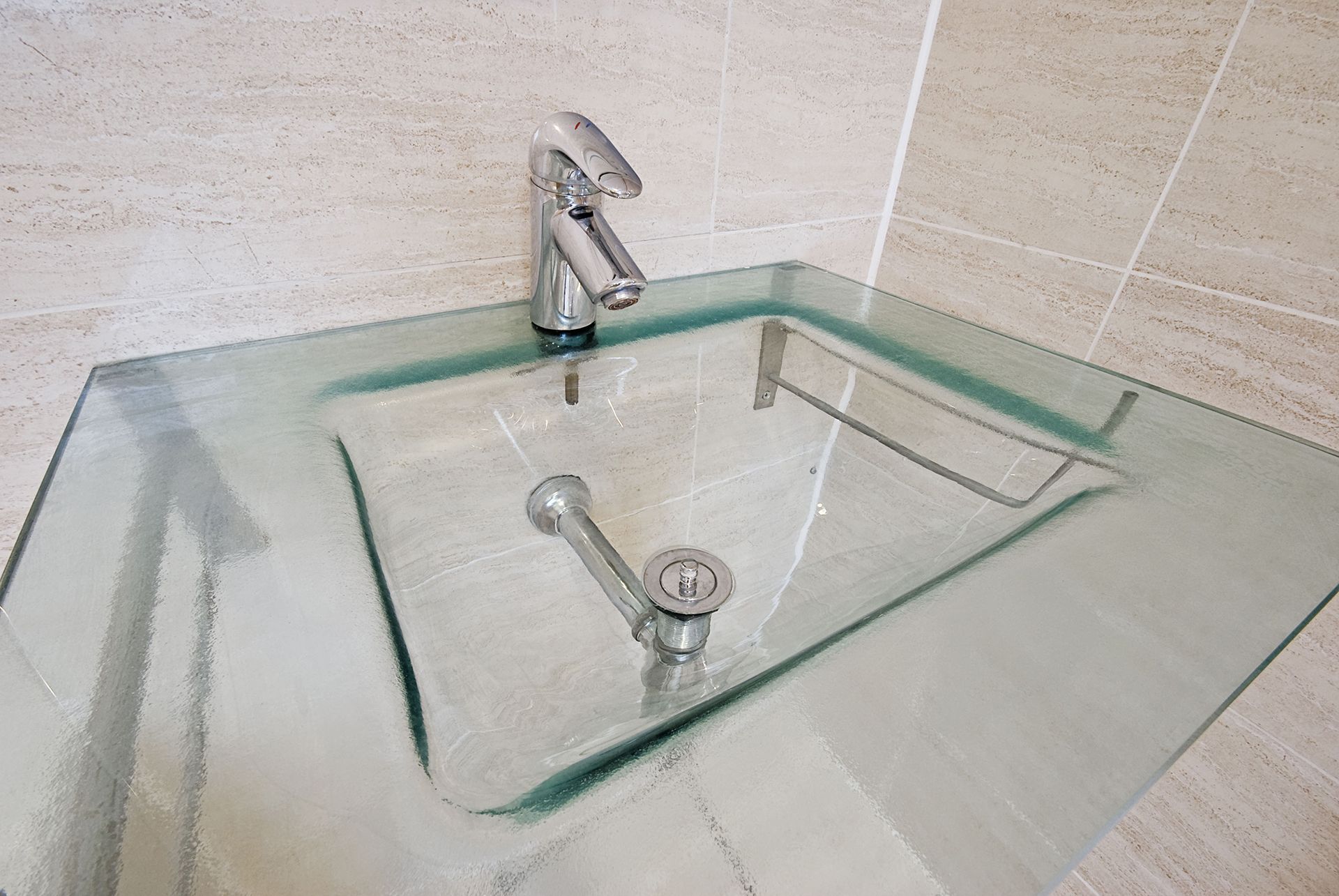 glass countertop sink with chrome faucet in a bathroom