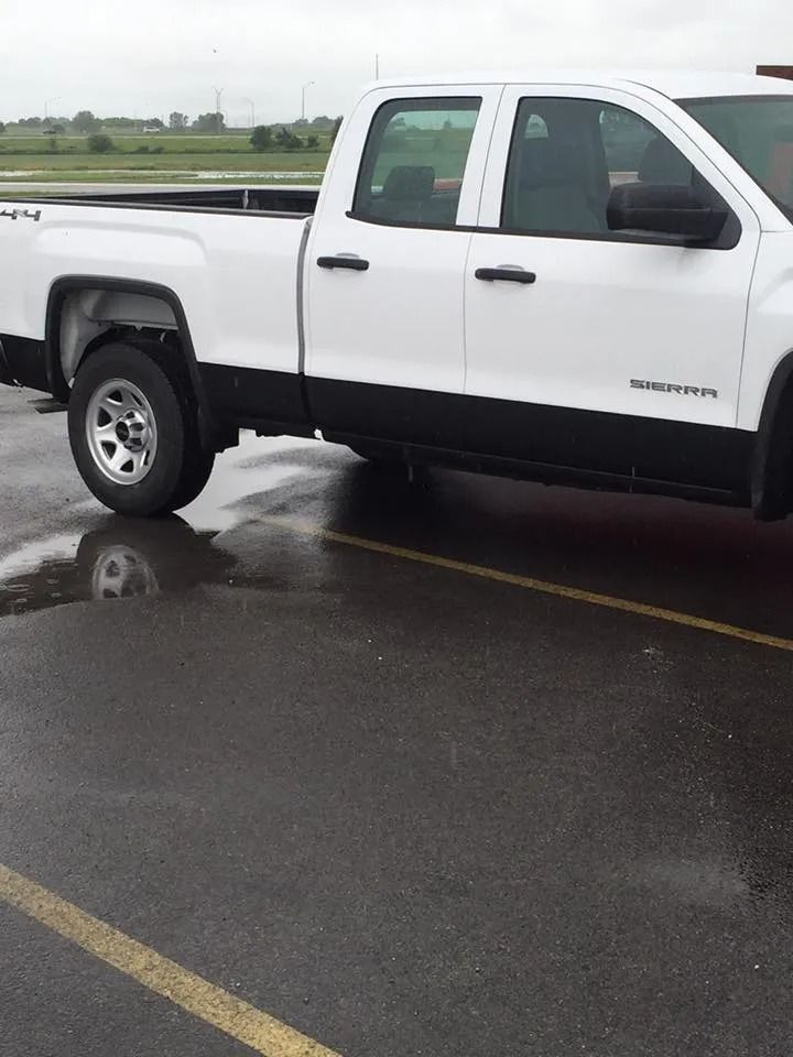 White pickup truck parked on wet asphalt.
