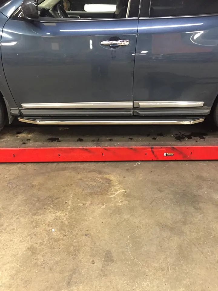 Blue car on a lift; chrome running board.