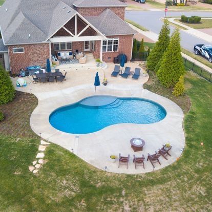 An aerial view of a house with a large swimming pool