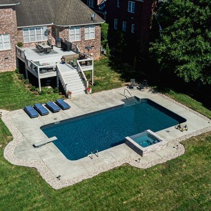An aerial view of a large swimming pool in the backyard of a house