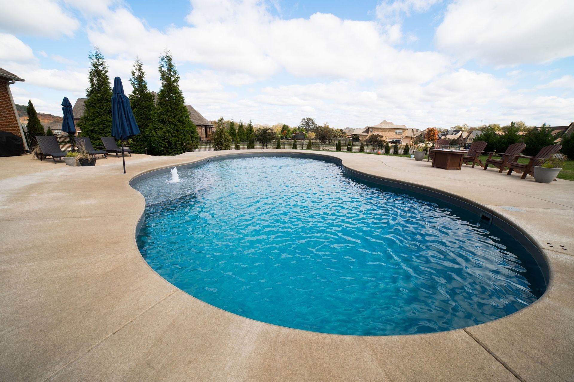 A large swimming pool with umbrellas and chairs around it