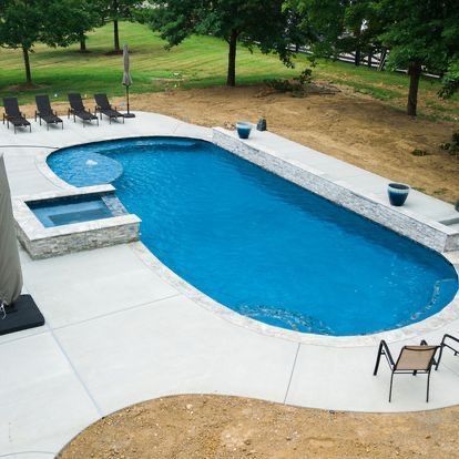 A large swimming pool with chairs and umbrellas around it