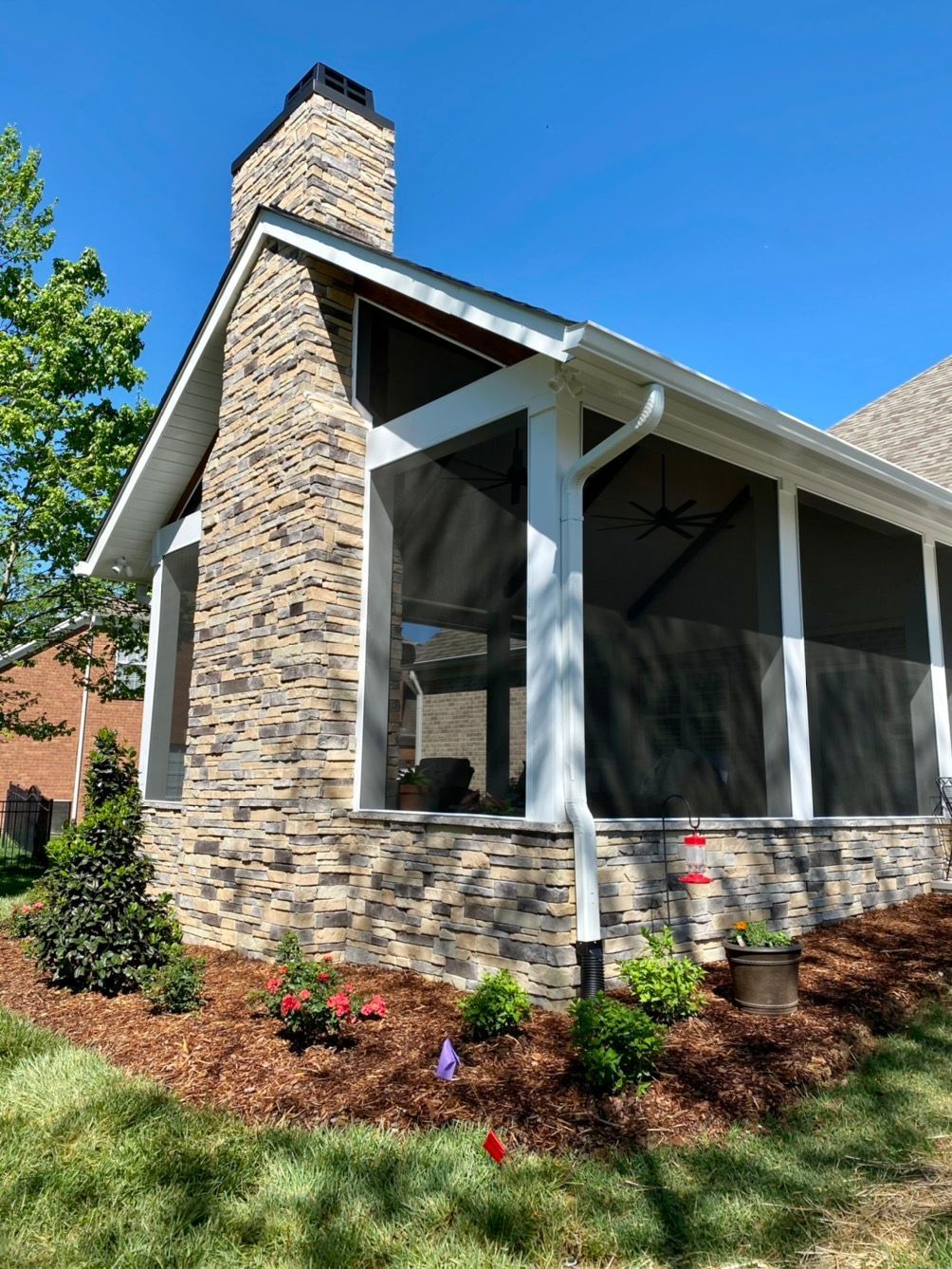 A screened-in porch with a brick wall.