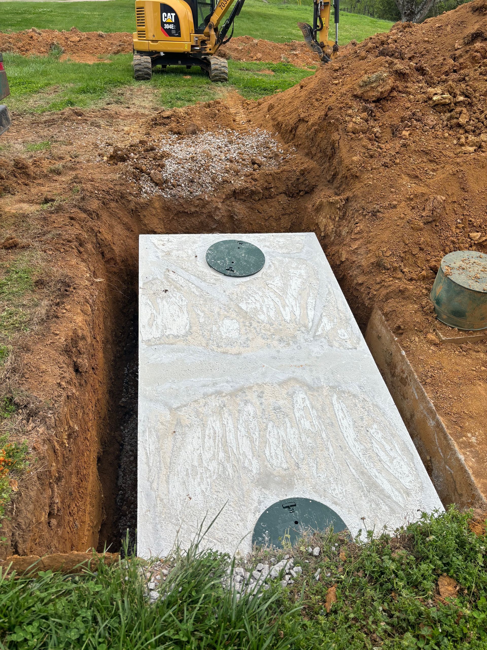 A septic tank is being installed in a hole in the ground.