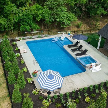 An aerial view of a large swimming pool surrounded by chairs and umbrellas.