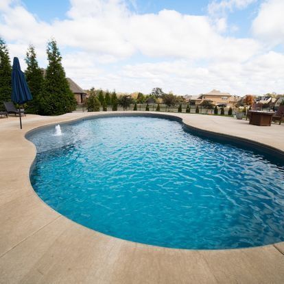 A large swimming pool with a fountain in the middle