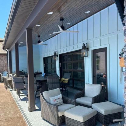 There are a lot of chairs and ottomans on the porch.