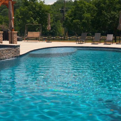 A large swimming pool surrounded by chairs and umbrellas.
