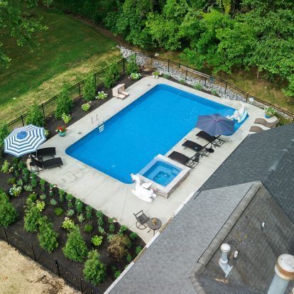 An aerial view of a large swimming pool with umbrellas and chairs