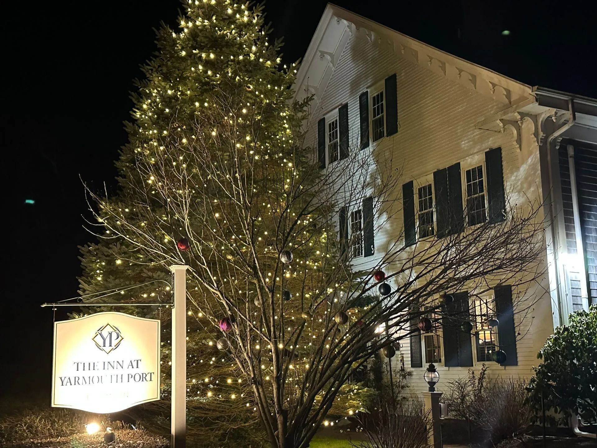 White building with Christmas lights; sign reads