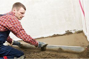 Man in red long sleeves shirt cementing the floor